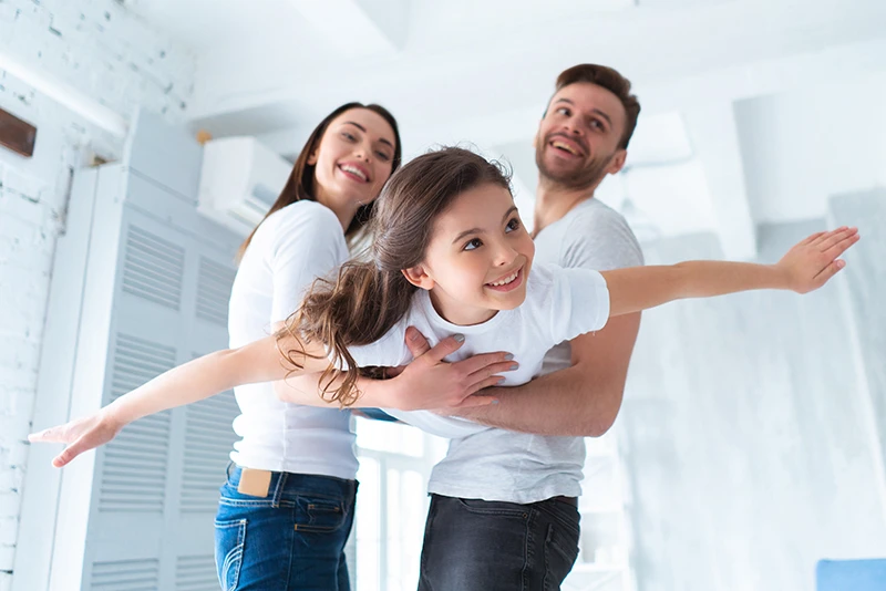 Indoor Air Quality Family enjoying clean indoor air quality and comfort in a bright home living room.